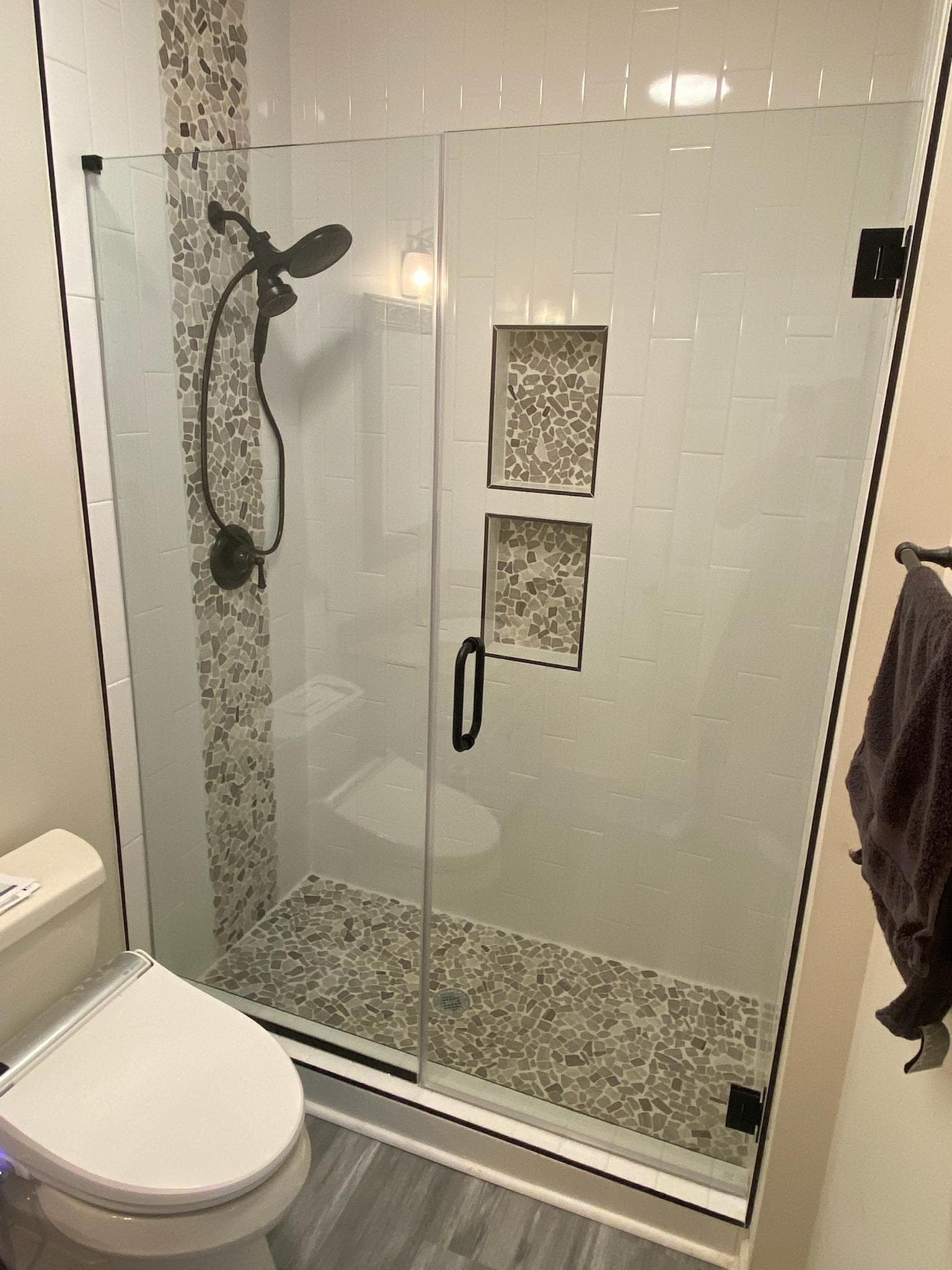Shower with stone tile accents and built-in niches