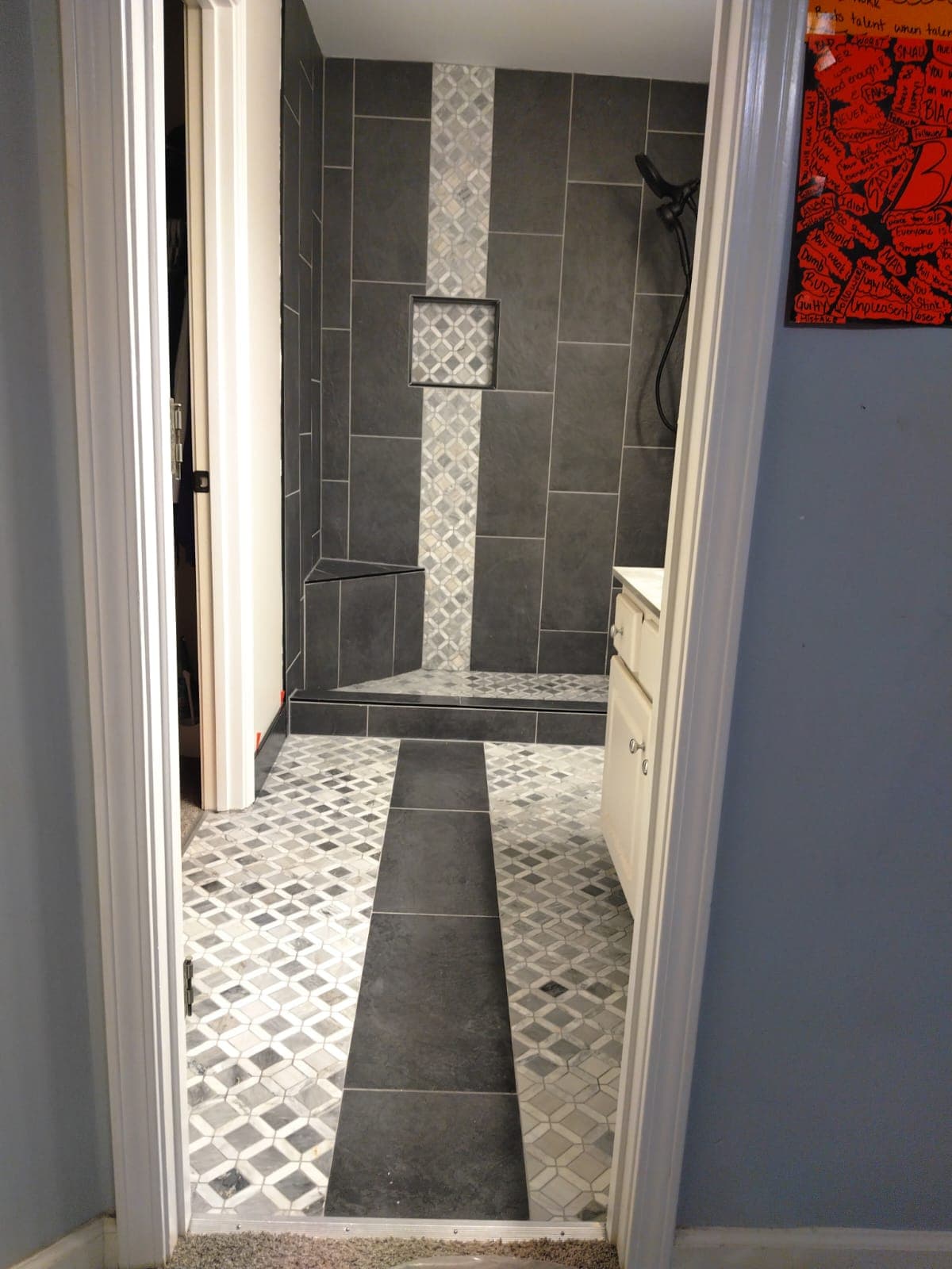 Bathroom with dark tile shower and patterned floor