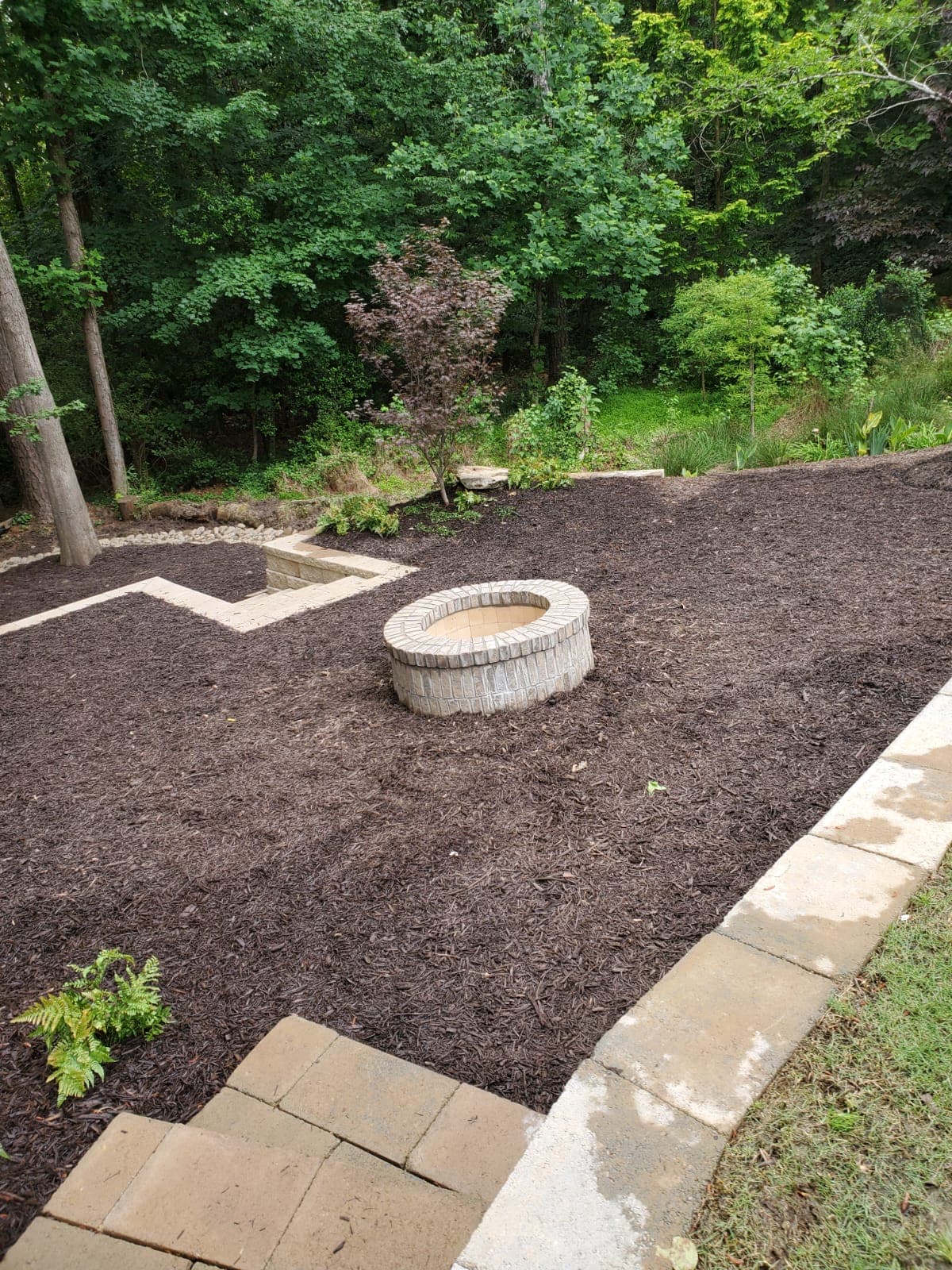 Custom stone fire pit with mulch landscaping