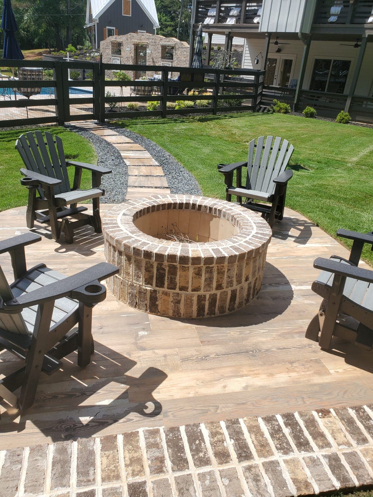 Brick fire pit with wood-look paver patio and seating