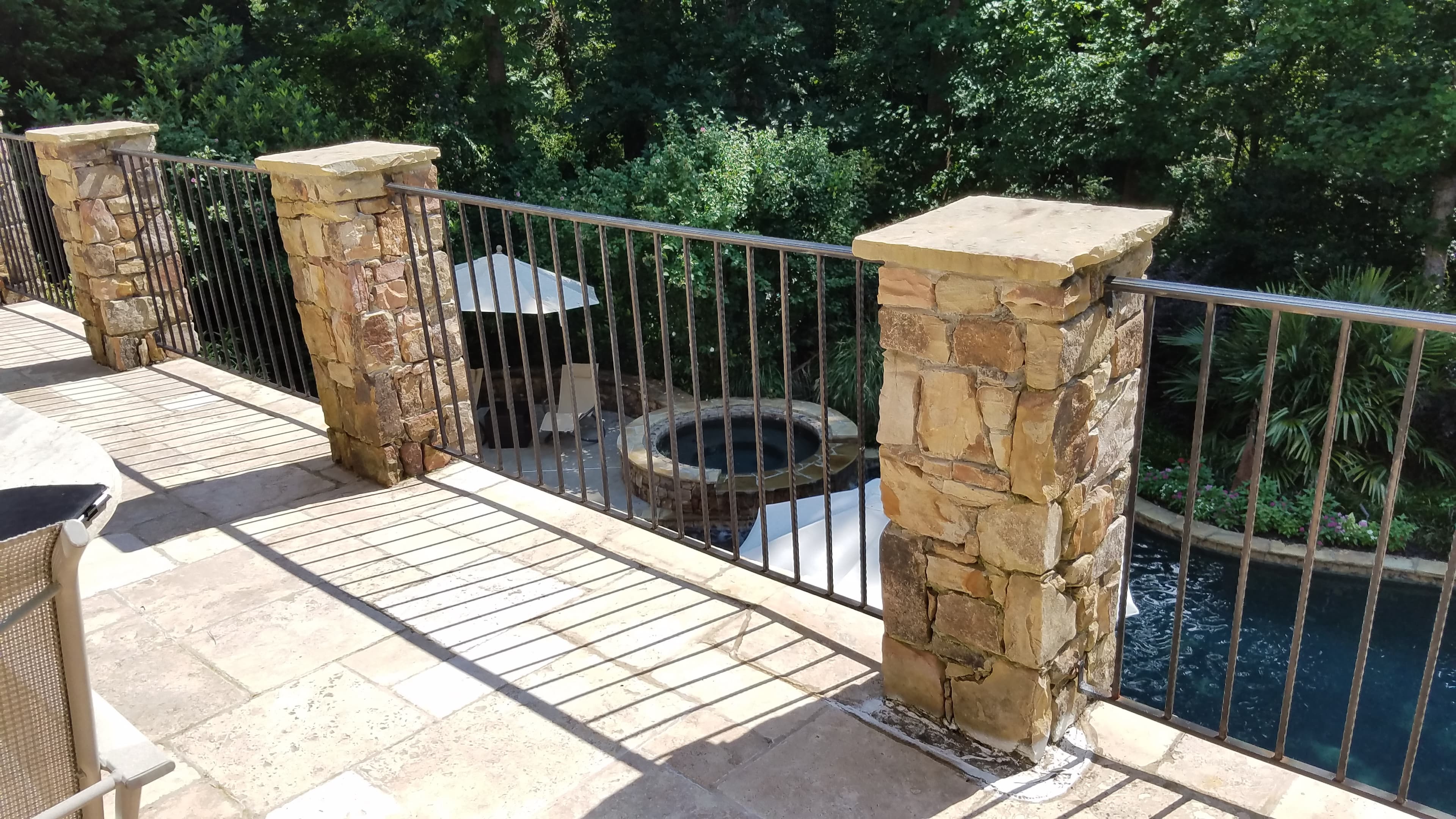 Patio with stone tile overlooking pool